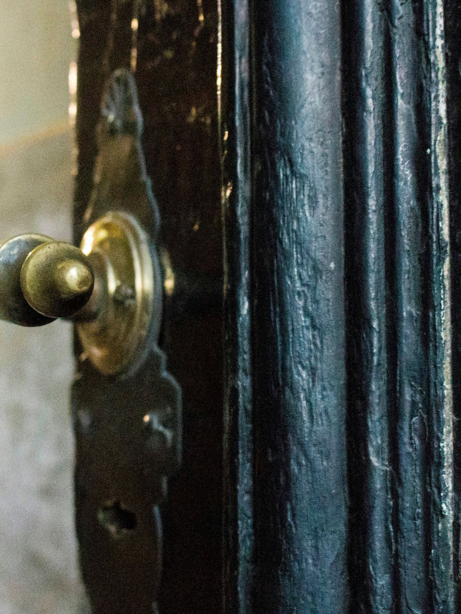 A brass door handle and lock plate on a painted timber door