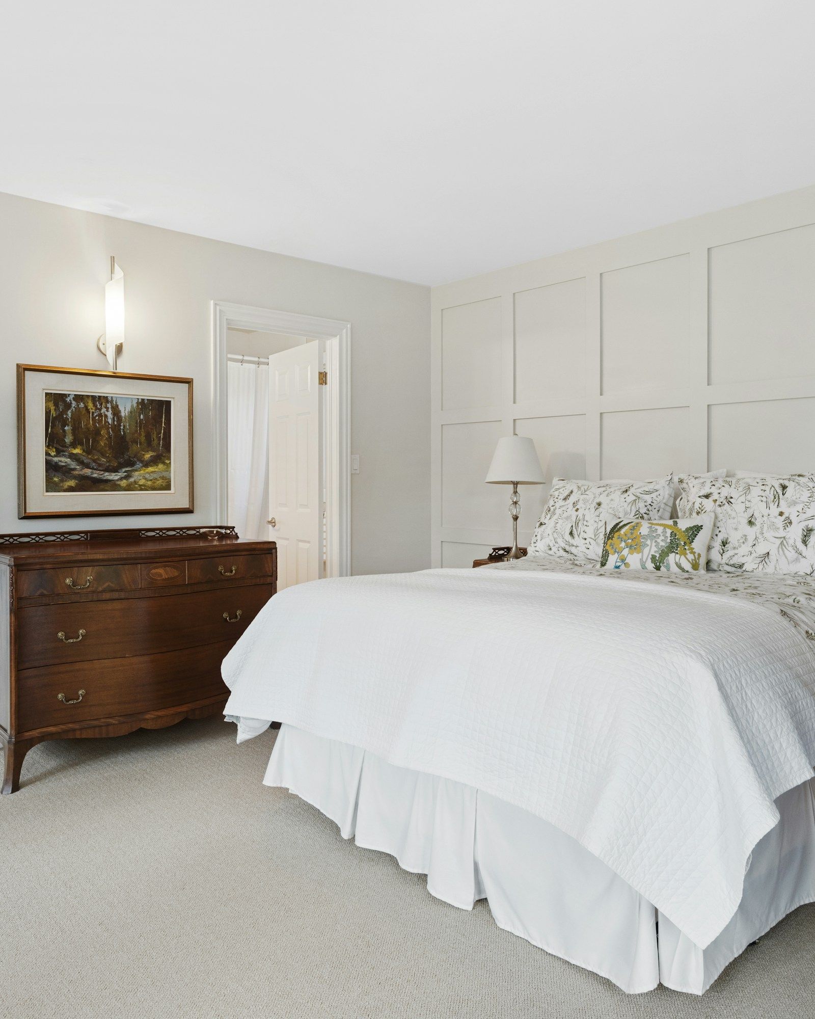 The principal bedroom with a square-panelled feature wall behind the bed
